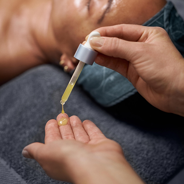 Medical esthetician dispensing serum during a Plump Peel facial